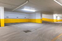 the inside of an empty yellow and white garage with yellow painted walls and ceiling lamps