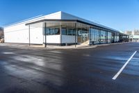 the modern office building is next to a parking lot area with no traffic on it