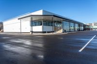 the modern office building is next to a parking lot area with no traffic on it