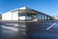 the modern office building is next to a parking lot area with no traffic on it