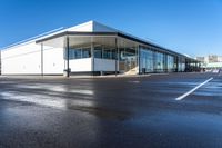 the modern office building is next to a parking lot area with no traffic on it