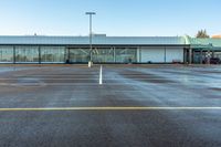 a empty parking lot in a big, empty parking lot with only one car and two people walking in the lot