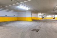 a large warehouse space with yellow painted walls and white doors and a car parked in the parking lot