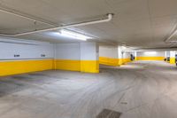 a large warehouse space with yellow painted walls and white doors and a car parked in the parking lot