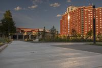 a city street surrounded by grass and tall buildings at the end of a street there is a paved pathway in front of the building