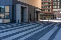 the sidewalk is empty in front of a building and has a black and white checkered pattern