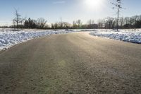 a paved road that has some snow on top of it in the middle of the day