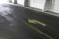 there is an arrow drawn on the concrete floor in the parking garage, which looks like a sign for someone