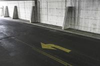 there is an arrow drawn on the concrete floor in the parking garage, which looks like a sign for someone