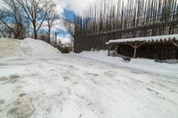 this is the road going down to the snow covered park area under a blue sky and white clouds