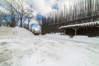 this is the road going down to the snow covered park area under a blue sky and white clouds