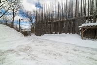 this is the road going down to the snow covered park area under a blue sky and white clouds