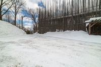 this is the road going down to the snow covered park area under a blue sky and white clouds