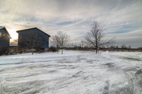 two barn houses on the street are covered in snow and ice after a winter storm