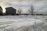 two barn houses on the street are covered in snow and ice after a winter storm