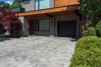 an driveway area and garage that has stone and gravel with a large front porch and garage on the other side with wood on top