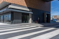 a bicycle is parked outside the building, looking into it from across the street from the sidewalk,