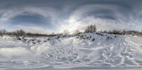 a skiier walks up a slope while snow covers the ground and trees surround him