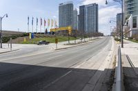 an empty highway with a parking lot underneath it and street lights and tall buildings on both sides