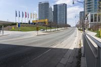 an empty highway with a parking lot underneath it and street lights and tall buildings on both sides