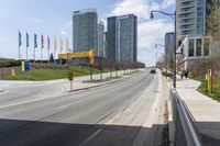 an empty highway with a parking lot underneath it and street lights and tall buildings on both sides