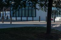 two people are standing on the sidewalk in front of an office building that has windows