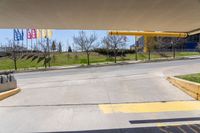 a stop sign is shown in front of an airport walkway with flags on the street