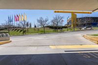 a stop sign is shown in front of an airport walkway with flags on the street