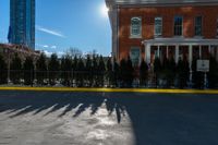 there is a long shadow of people riding on a skateboard with buildings in the background