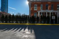 there is a long shadow of people riding on a skateboard with buildings in the background