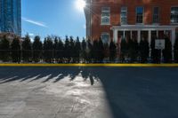 there is a long shadow of people riding on a skateboard with buildings in the background