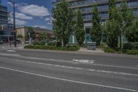 two white lines on the street as a stop light appears to point towards it and an apartment building to the right