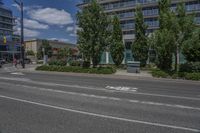 two white lines on the street as a stop light appears to point towards it and an apartment building to the right