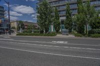 two white lines on the street as a stop light appears to point towards it and an apartment building to the right