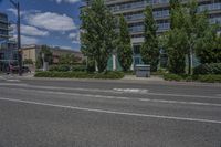 two white lines on the street as a stop light appears to point towards it and an apartment building to the right