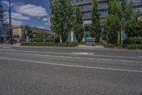 two white lines on the street as a stop light appears to point towards it and an apartment building to the right