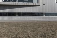 the white building is near a city street light and grass next to it and there are windows