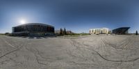 an empty parking lot with lots of cars parked and several other buildings behind it in a city