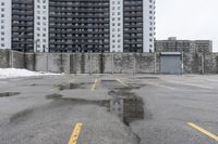 the empty parking lot has only snow on the ground in front of an old brick factory