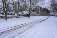 an empty snow covered street with lots of footprints in it and snow all over the ground