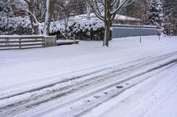 an empty snow covered street with lots of footprints in it and snow all over the ground