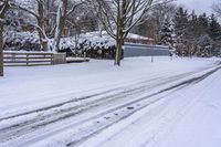 an empty snow covered street with lots of footprints in it and snow all over the ground