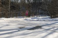 a sign that has a stop written next to it with snow on the ground nearby