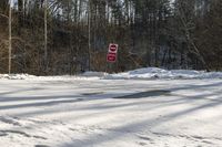 a sign that has a stop written next to it with snow on the ground nearby