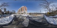 a long snowy road in front of buildings and houses with snow covering the road way