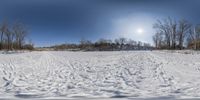 there is a snow covered field with skis in the background of the sun and trees