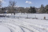 the dirt road has been cleared by a few thick snow tires in this snowy field