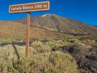 the sign points to a road and some bushes near a mountain with the words canada blanca