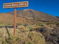 the sign points to a road and some bushes near a mountain with the words canada blanca