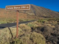 the sign points to a road and some bushes near a mountain with the words canada blanca